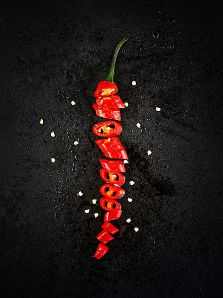 Sliced ​​chili pepper on black background